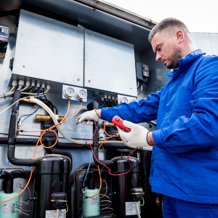 Technician servicing commercial refrigeration system outdoors